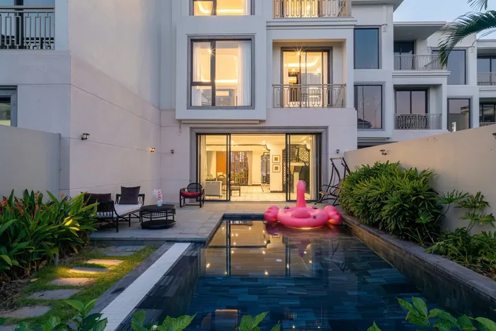 Mặt tiền La Vida Villa Grand Bay lúc hoàng hôn với bể bơi riêng thắp sáng
